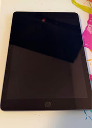 Apple iPad 6th Generation 128GB tablet showing the screen and sleek design in a natural setting.
